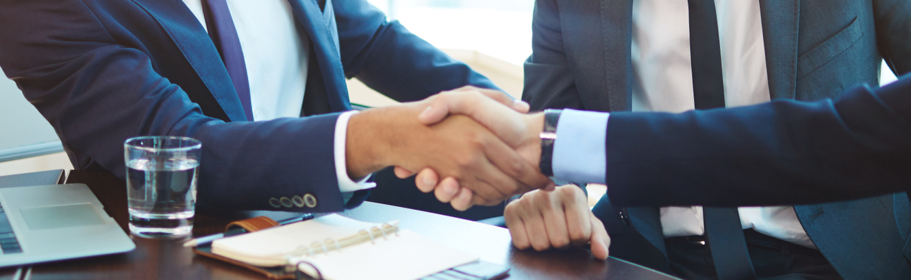 Two men in suits shaking hands